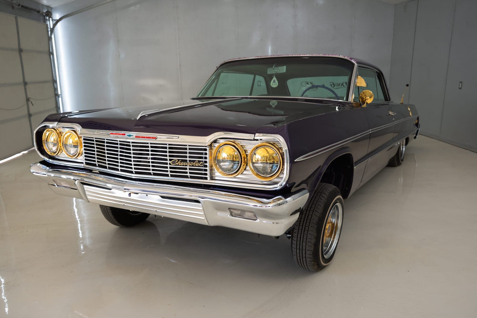 Lala — purple 1964 Chevrolet Impala lowrider with gold headlamps, three-quarter front